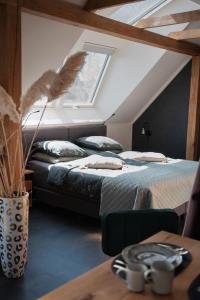 2 bedden in een zolderkamer met een raam bij Loft 32 in Winsum