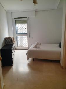 een kleine slaapkamer met een bed en een raam bij Torneo Life Tranquilo en el centro in Sevilla