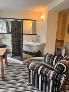 uma sala de estar com uma banheira e um sofá em The Oxfordshire em Blackpool