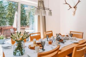 een eetkamer met een tafel met eten erop bij Ferienhaus Florianiweg in Bad Gastein
