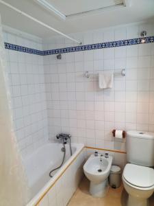 een badkamer met een toilet, een bad en een wastafel bij Torneo Life Tranquilo en el centro in Sevilla