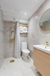 a bathroom with a toilet and a sink and a mirror at At Old Town Aparthotel in Stockholm