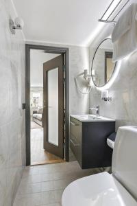 a bathroom with a toilet and a sink and a mirror at At Old Town Aparthotel in Stockholm