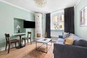 uma sala de estar com um sofá azul e uma mesa em At Old Town Aparthotel em Estocolmo