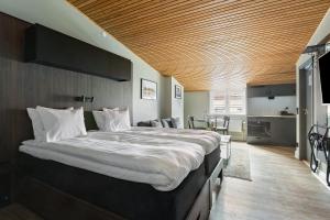 a bedroom with a large bed with a wooden ceiling at At Old Town Aparthotel in Stockholm