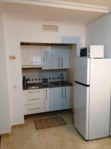 a kitchen with white cabinets and a white refrigerator at Torneo Life Tranquilo en el centro in Seville