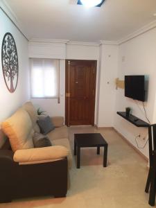 een woonkamer met een bank en een tv bij Torneo Life Tranquilo en el centro in Sevilla
