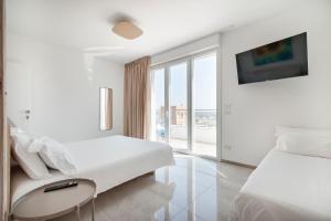 biały pokój z 2 łóżkami i oknem w obiekcie THE VIEW B&B, terrace & more w mieście San Foca