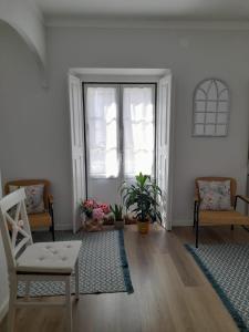 a living room with a chair and a window at Cantinho do Céu in Alcácer do Sal