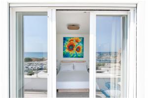 een kamer met een bed en een schilderij aan de muur bij THE VIEW B&B, terrace & more in San Foca