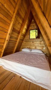 a bed in a wooden cabin with a window at Horizon Lodge Medurec in Ulcinj