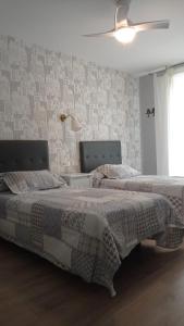 - 2 lits installés l'un à côté de l'autre dans une chambre dans l'établissement Serendipia Apartamentos 3, à Logroño