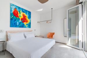 - une chambre avec un lit blanc et une peinture murale dans l'établissement THE VIEW B&B, terrace & more, à San Foca