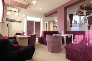 a living room with pink furniture and a table and chairs at Студио Ариел in Varna City