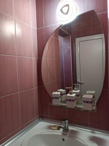 baño con lavabo y espejo grande en Студио Ариел, en Varna