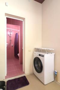 y baño con lavadora y ducha de color rosa. en Студио Ариел, en Varna