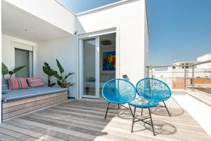 Duas cadeiras azuis e um sofá na varanda. em THE VIEW B&B, terrace & more em San Foca