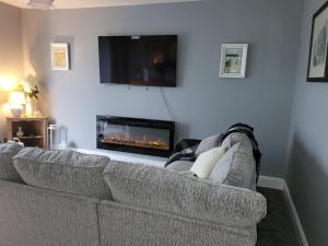 a living room with a couch and a fireplace at Snowdon view, steam railway & Portmeirion nearby in Mynfford