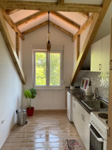 Una cocina con gabinetes blancos y una ventana. en Naš san, en Vrdnik 13 fotos más