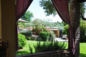 una ventana con vistas al jardín desde una casa en Piccolo Feudo Green Resort, en Viterbo