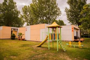 um parque infantil com um escorrega num quintal em Enigma Resort em Mamaia