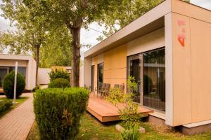 een huis met een houten terras in een tuin bij Enigma Resort in Mamaia