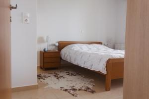 a bedroom with a bed and a night stand and a rug at Villa Cook with pool and terraces with sea views in Dhaskalianá