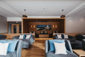 a living room with blue chairs and a couch at Naturhotel Bauernhofer in Heilbrunn