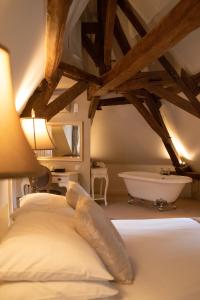 1 dormitorio con cama y bañera en Logis Hotel De France, en La Chartre-sur-le-Loir