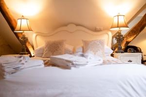 a bedroom with a white bed with two lamps at Logis Hotel De France in La Chartre-sur-le-Loir +78 photos