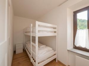 Ce lit superposé blanc se trouve dans un dortoir doté d'une fenêtre. dans l'établissement Luxury apartment in Bormio - Centrale 69, à Piatta