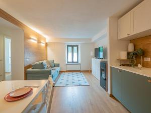 Il comprend une cuisine et un salon avec un canapé. dans l'établissement Luxury apartment in Bormio - Centrale 69, à Piatta