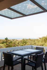 a table and chairs on a balcony with a view of the ocean at Villa Cook with pool and terraces with sea views in Dhaskalianá