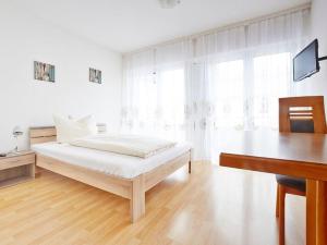 Habitación blanca con cama y escritorio en Hotel Scheffelhof en Bad Säckingen