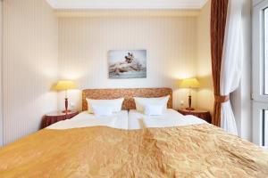 a hotel room with a large bed with two lamps at Strandhotel Sylt Westerland in Westerland