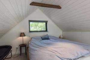 a bedroom with a bed and a window in a attic at Sea view Myttinge in Värmdö