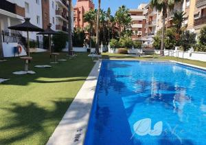 a large blue swimming pool in a building at PUSHE Playa Granada Beach & Golf 17 in Motril
