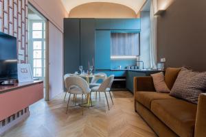 uma sala de estar com um sofá, uma mesa e cadeiras em Lagrange Design Apartments by Wonderful Italy em Turim