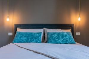 a bed with blue and white pillows on it at Lagrange Design Apartments by Wonderful Italy in Turin