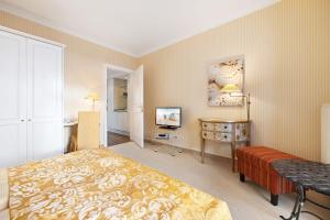 a bedroom with a bed and a desk and a television at Strandhotel Sylt Westerland in Westerland