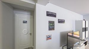 ein Zimmer mit einer weißen Tür und Schildern an der Wand in der Unterkunft WE ARE HOSTEL in Póvoa de Varzim