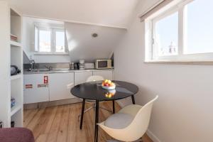 eine kleine Küche mit einem Tisch und Stühlen in einem Zimmer in der Unterkunft Apartamento vista rio Tejo em Alfama, TTL99 in Lissabon