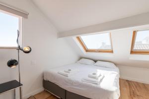 1 dormitorio con 1 cama con sábanas blancas y 2 toallas en Apartamento vista rio Tejo em Alfama, TTL99, en Lisboa