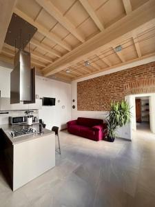 cocina con sofá rojo en la sala de estar en Dimora Boezio7, cozy and charming place in center with private parking, en Pavia