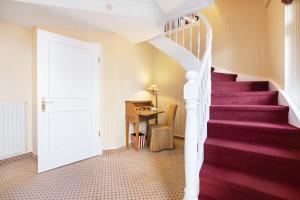 a staircase in a house with a red carpet at Strandhotel Sylt Westerland in Westerland