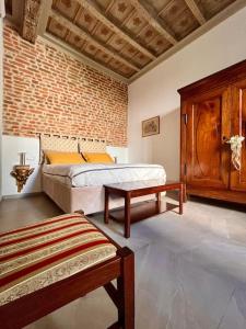 una camera con due letti e un muro di mattoni di Dimora Boezio7, cozy and charming place in center with private parking a Pavia