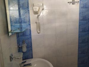 a bathroom with a toilet and a phone on the wall at Corali Hotel in Piso Livadi