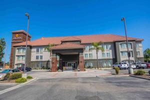 a hotel with a parking lot in front of it at La Quinta by Wyndham Fowler in Fowler