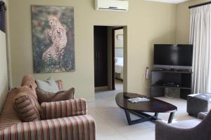 sala de estar con sofá y mesa en Mjejane Bush Camp by Dream Resorts, en Hectorspruit