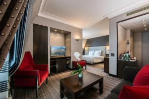 um quarto de hotel com uma cama e uma sala de estar em Hôtel Métropole Genève em Genebra